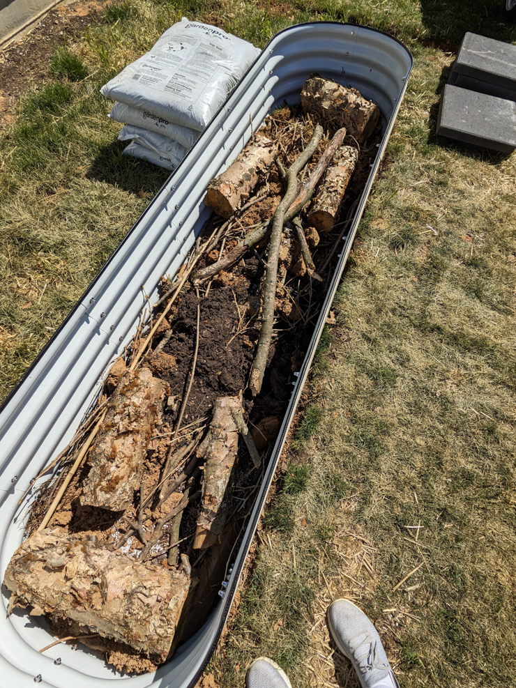 filling out the vego garden bed with sticks and logs