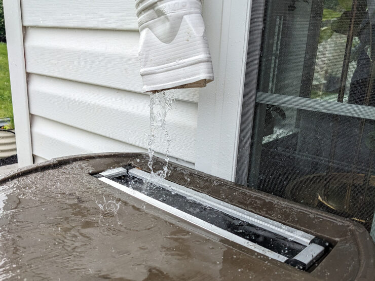 water flowing from a gutter into a rain barrel