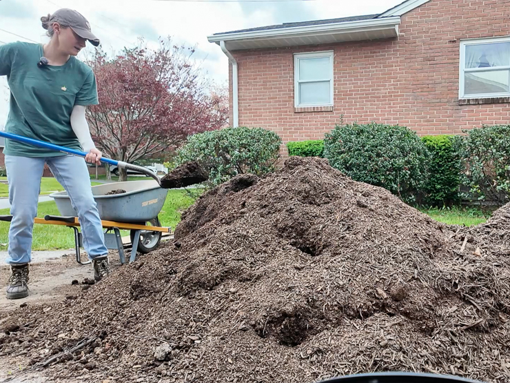 woman shoveling manure