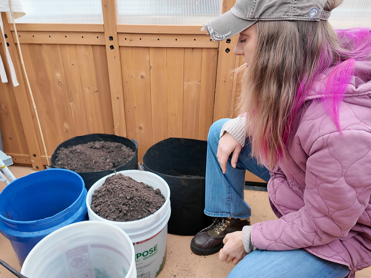 woman kneeling next to buckets