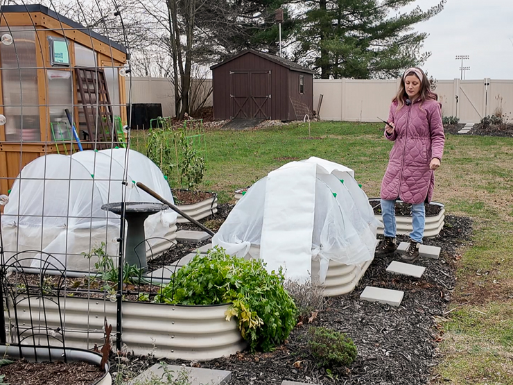 adding plastic sheeting to a hoop house
