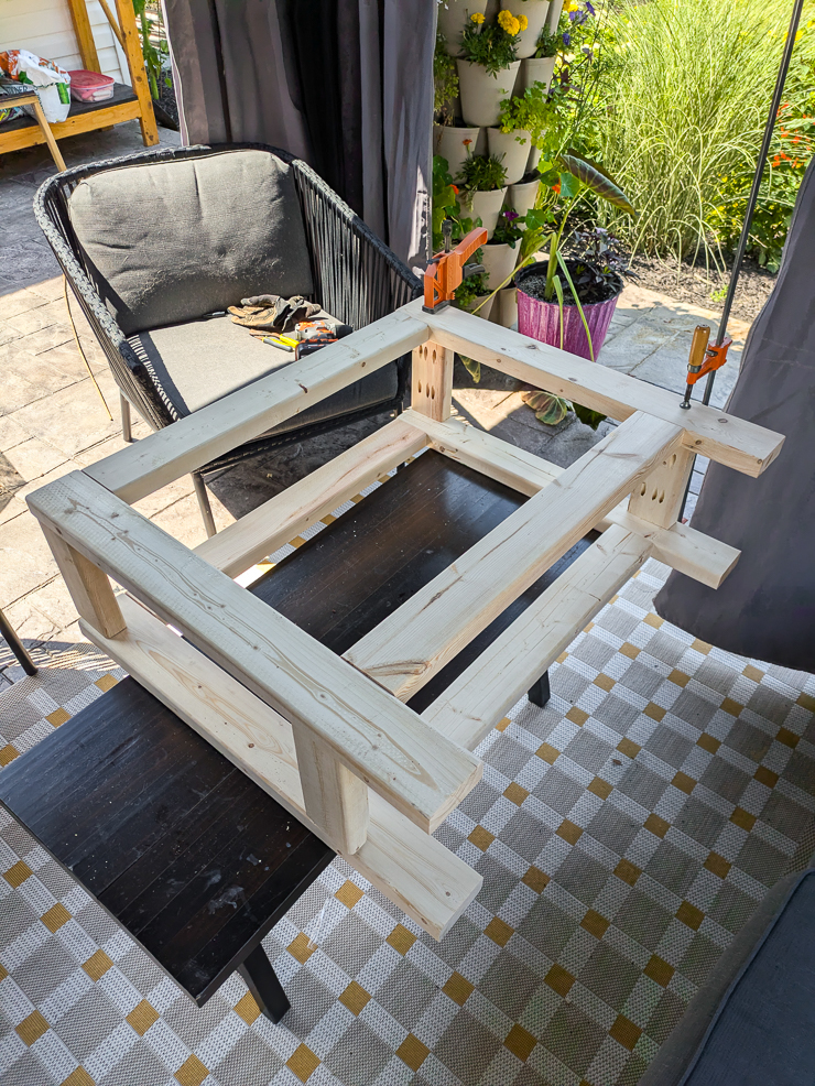 frame of a console table on its side with clamps