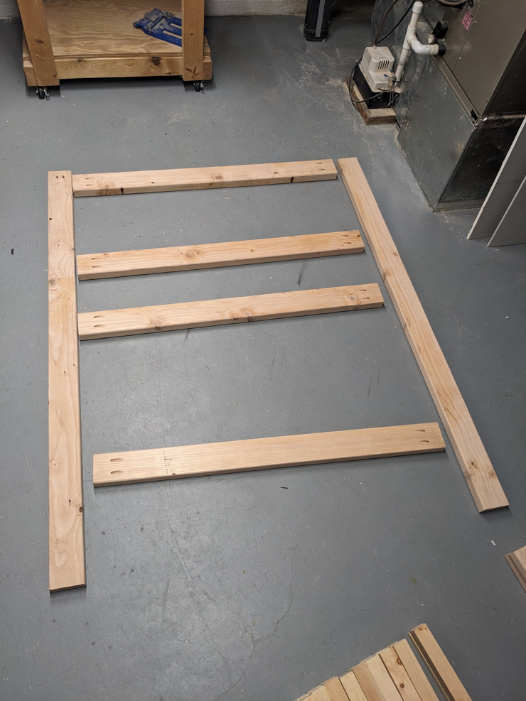 pieces of wood laid out on a floor to begin assembly