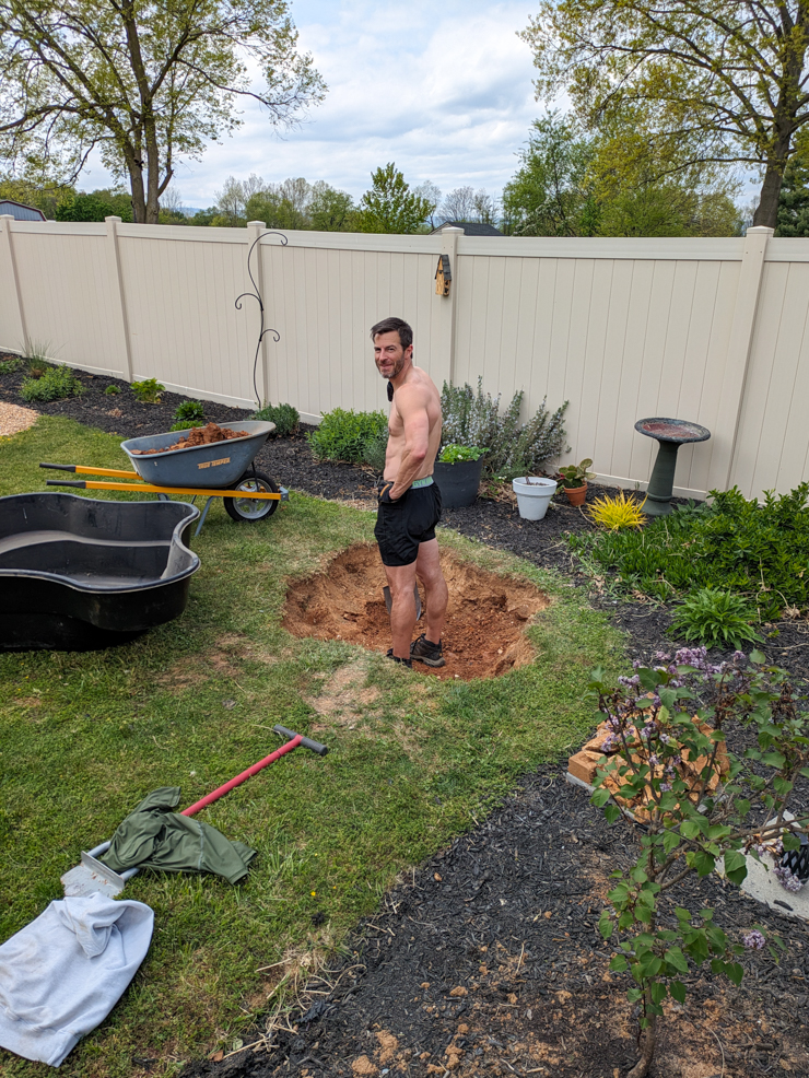 man digging a hole for a pond